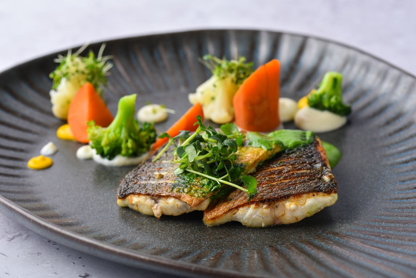 Filetto di branzino dell’Adriatico con purea di sedano, crema di spinaci e verdure