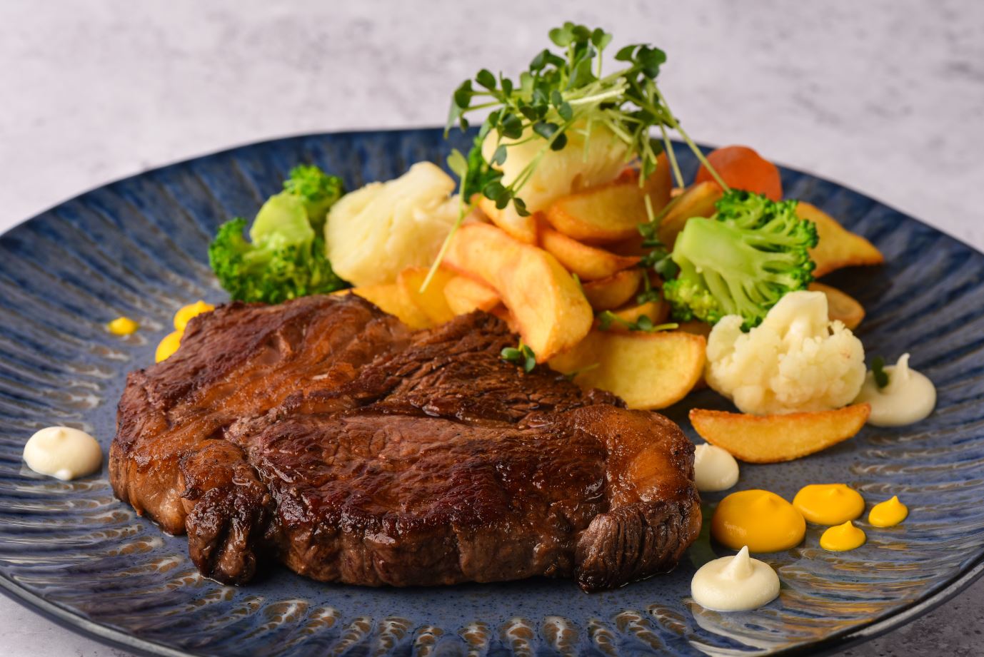 Rib eye steak with selected vegetables and potatoes